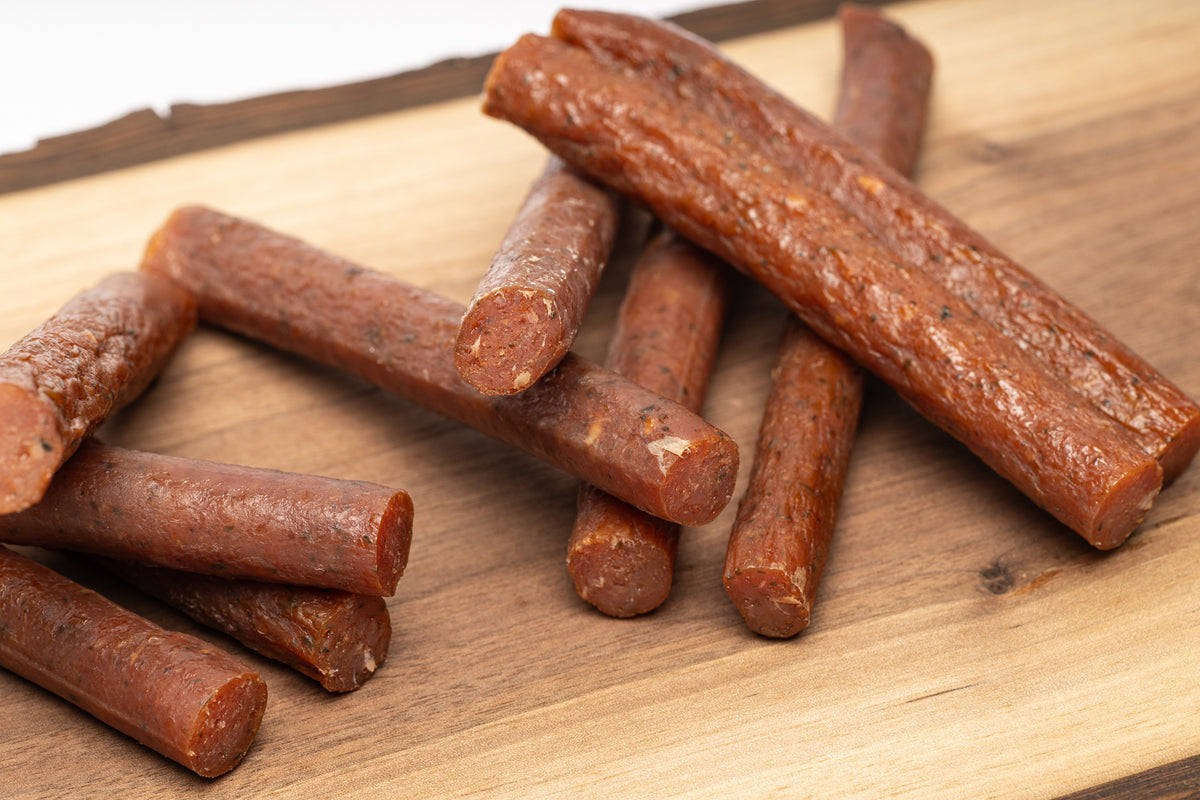 Corderro Premium chicken meat sticks with mild heat, shown in a box, highlighting the flavorful snack's texture and packaging.