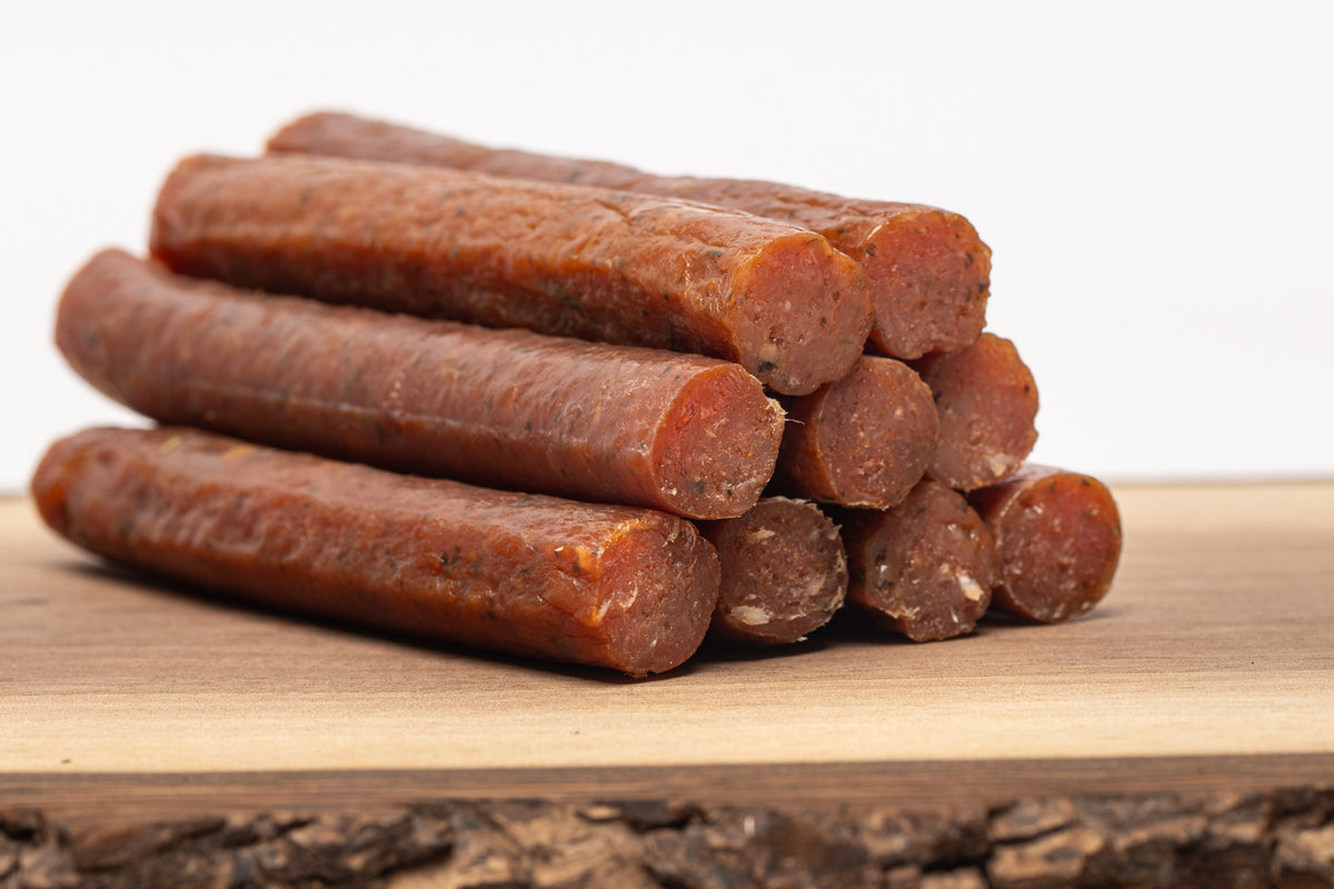 Corderro Premium chicken meat sticks with mild heat, showing four cooked chicken sticks on a plate, ready to serve.