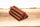 Stack of meat sticks on a wooden board.